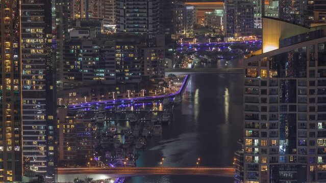 Close up view of Dubai Marina showing canal surrounded by skyscrapers along shoreline night timelapse. DUBAI, UAE