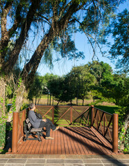 Man sitting and admiring the view at the decks by the river Paranhana in Tres Coroas, Rio Grande do Sul - Brazil