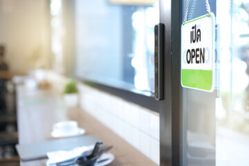 Open and closed flip sign in front of coffee shop and restaurant glass door. Wooden sign with...