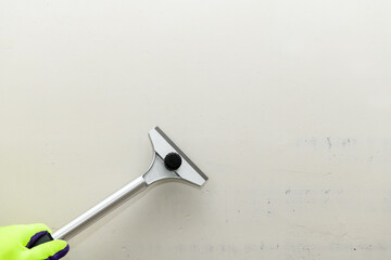 Construction scraper on gray wall background. Construction finishing works. Wall repair inside the...