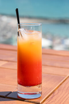 Colorful Red Orange Fruits Cold Icy Cocktail Glass On Beach