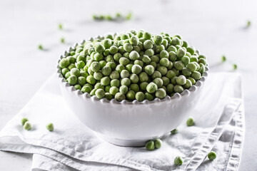 Frozen peas in a white porcelain bowl.