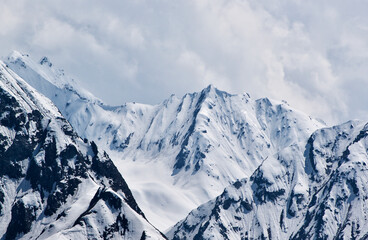 Mountainous landscape with snowy peaks behind Furka–Oberalp-Bahn in Switzerland in spring. - obrazy, fototapety, plakaty
