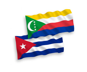 National vector fabric wave flags of Union of the Comoros and Cuba isolated on white background. 1 to 2 proportion.