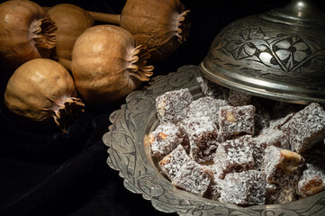Macro view of Turkish delight in hollowware with dried poppy plants