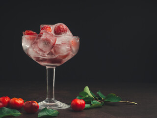 Wine glass with a fresh cherry on ice. Refreshing cold drink