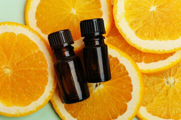 Essential oils in dark glass bottles on fresh slices of orange. Cosmetic, healthy concept