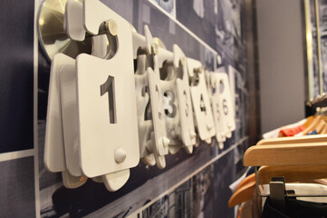 Closeup detail photo of fitting room numbers for clothing items