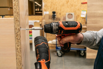 Cordless screwdriver in the hands of a worker