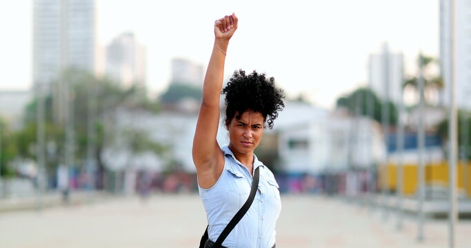 Proud young black woman raising fist in the air in protest
