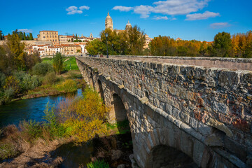 Naklejka premium Salamanca, Spain - november 6 2022 - tourists and locals visiting the prehistoric roman bridge (Puente Romano) at the edge of town
