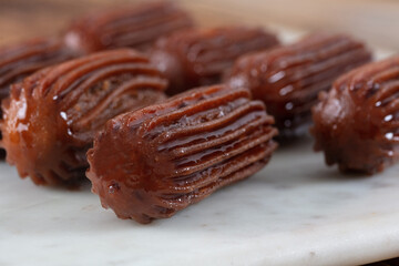 Chocolate Tulumba dessert served on the marble 