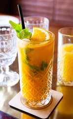 non alcoholic sea buckthorn cocktail with mint and orange in a glass glass