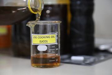 used cooking oil in glass cups for biodiesel feedstock. used cooking oil for soap. the concept of...