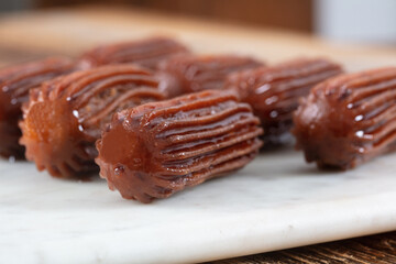 Chocolate Tulumba dessert served on the marble 