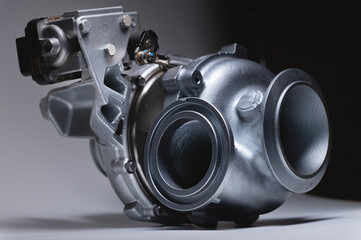 New turbocharger with aluminum cold section. on a gray contrasting background. car engine...