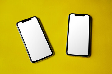 Double smartphone screen mockup above flat paper texture by real photography