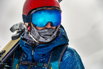 Closeup portrait of ski goggles of a man with reflection of snowy mountains. The mountain range is...