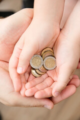 Adult giving coin to a child as saving money concept. Children's financial education, financial...