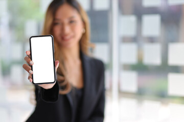 Copy space on mobile phone screen. Woman holding and showing smartphone.
