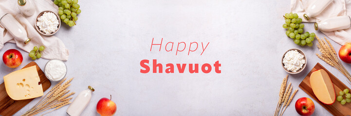 Shavuot flat lay web banner with dairy products, first fruits and wheat on light gray background