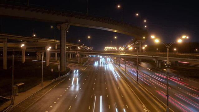 Time lapse of traffic on a night road. Light trails of moving cars on a modern highway