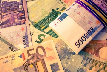 A pack of European currency lies on the background of the Euro
