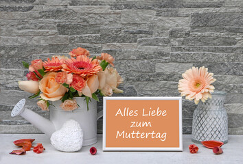 Blumenstrauß mit Rosen und Gerbera vor einer Steinwand mit dem Text Alles Liebe zum Muttertag auf...