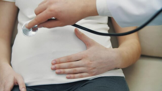 4k slow motion close up video of doctor examining pregnant woman with a stethoscope.