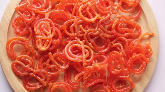 slow motion of jalebi indian sweet drops on a plate 