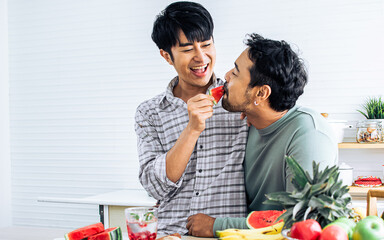 Gay LGBT sweet Asian couple wearing pajamas, smiling with happiness and love, eating, feeding...