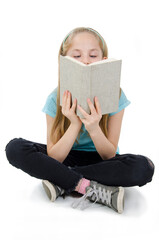 Education and school concept - adorable girl sitting on floor and reading book. Isolated on white background 