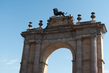 Fototapeta na wymiar arco de león Guanajuato con león de cemento en lo alto y cielo azul despejado