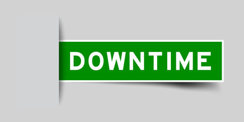 Inserted green color label sticker with word downtime on gray background
