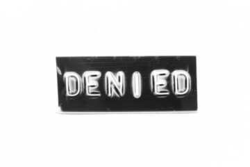 Black color banner that have embossed letter with word denied on white paper background
