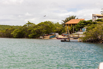 brazilian beach with vegetation, blue sea and cloudy sky
