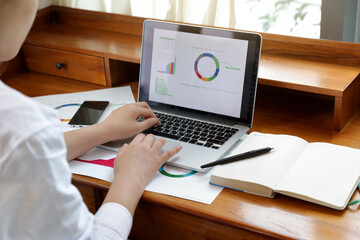  A woman using computer prepare financial graph diagram
