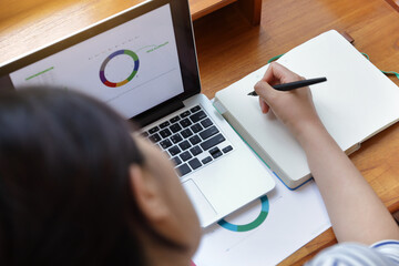  A woman using computer prepare financial graph diagram