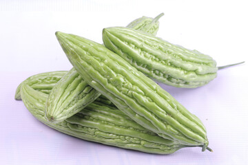 pile of fresh bitter gourds on white, isolated