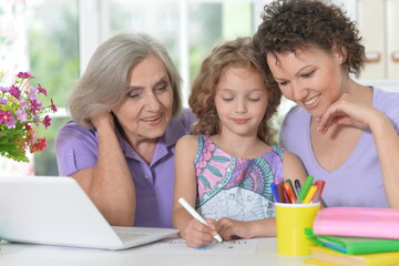 Mother, grandmother and girl  drawing together