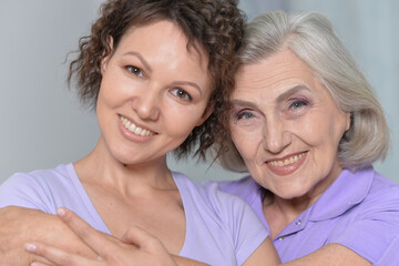 Mature woman embracing with adult daughter at home