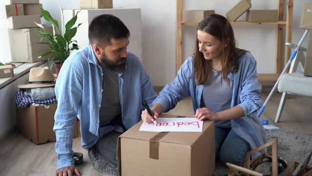 young married couple moves to a new house, packing boxes with things, carrying a bedroom box, relocation and a new apartment, happy home owners