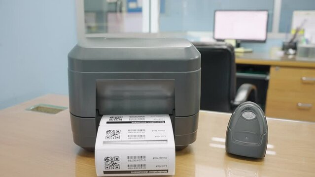 The black barcode printer is printing the bar code or QR code on the sticker.