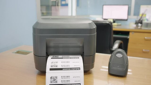 The black barcode printer is printing the bar code or QR code on the sticker.