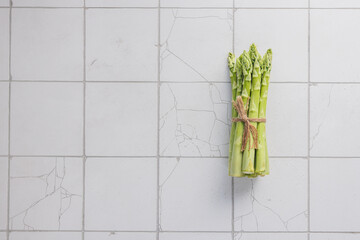 Fresh organic raw green asparagus on the kirchen  background with copy space for your text. Healthy diet food concept.