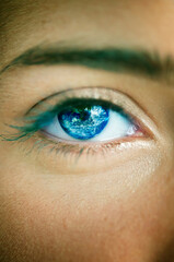 young woman eye with planet Earth inside the iris