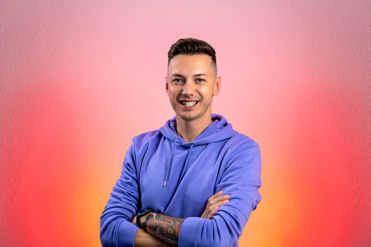 Smiling young good looking man standing against red gradient background