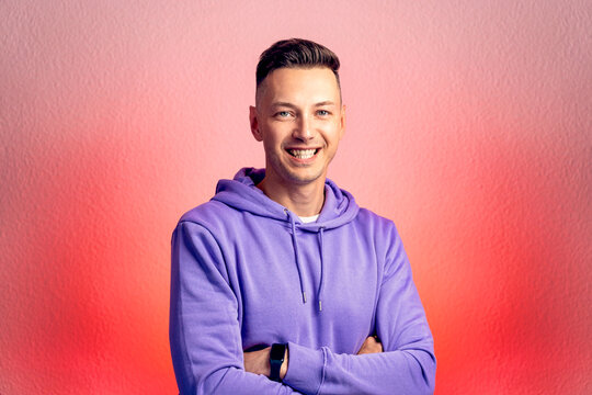 Smiling young good looking man standing against red gradient background