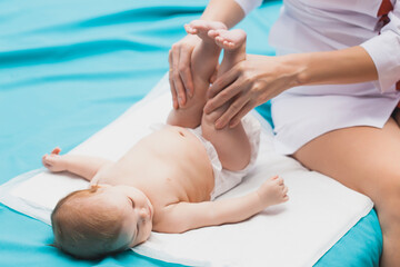 doctor woman doing gymnastic massage cute newborn.