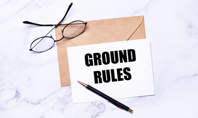 On a light marble background, a craft envelope, glasses, a pen and a white card with the text...